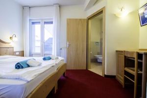 a bedroom with a large bed and a bathroom at Liz Hotel & Apartments in Predazzo