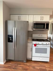 a kitchen with a stainless steel refrigerator and white cabinets at Lonnie in Westland