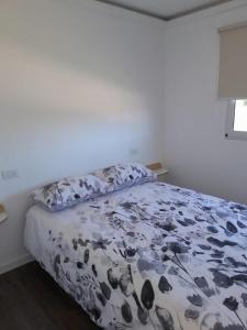a bedroom with a bed with a floral comforter at Villa Pi in Miramar