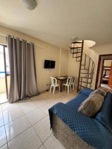 a bedroom with a bed and a table with chairs at Praias do Sul in Cabo Frio