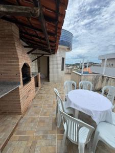 a patio with a table and chairs and a brick oven at Praias do Sul in Cabo Frio