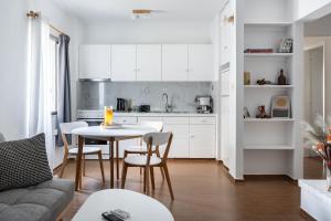 a kitchen and dining room with a table and chairs at Saronida Coastal Escape 2BR Apartment in Saronida