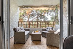 a patio with wicker chairs and a table at Saronida Coastal Escape 2BR Apartment in Saronida