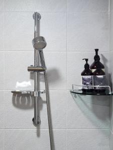 a shower with two shelves in a bathroom at Gaegum Moonlight Stay in Busan +39 photos