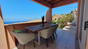 a table and chairs on a balcony with a view of the ocean at Poolvilla Bellavista - Vista Panoramica sul Mare in Costa Paradiso