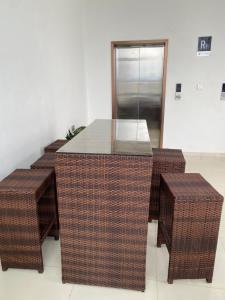 a table and three wicker stools in a room at Luxeliving Homes in Nairobi