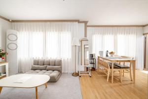 a living room with a couch and a table at Gaegum Moonlight Stay in Busan