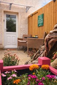 a patio with a white door and some flowers at The Éire Escape Countryside Studio near Newgrange & Dublin in Slane