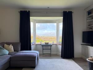 a living room with a couch and a large window at Waterville Links in Waterville