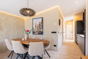 a dining room with a wooden table and white chairs at De Leughte in Renswoude