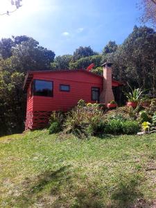 a red house sitting on top of a grass field at Las Bromelias Lodge in Paso Macho +9 photos