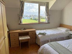 a small bedroom with two beds and a window at Waterville Links in Waterville