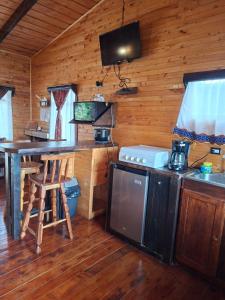 a kitchen in a log cabin with a table and a stove at Las Bromelias Lodge in Paso Macho