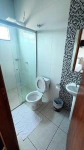 ein Badezimmer mit Dusche, Toilette und Waschbecken in der Unterkunft Alfa Hotel in Nerópolis + 27 Fotos
