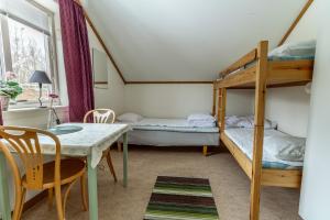 a small room with two bunk beds and a table at Öje Vandrarhem & Turistgård in Östra Öje