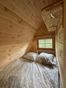 a bedroom with a bed in a wooden cabin at LOGEMENT INSOLITE Pod sur Pilotis in Molineuf