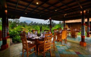De Klumpu Bali Eco Tradi Stay في Bangli: غرفة طعام مع طاولة وكراسي مطلة