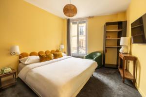 a bedroom with a large bed and a window at Hôtel d'Angleterre in Versailles