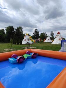 a group of tents in a field with a water park at Osada Indiańska in Ostrów Podlaski