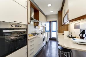 a kitchen with white appliances and a counter top at Apartamento Mar Salgado Ericeira in Ericeira