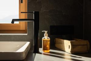 a bottle of soap sitting on a counter next to a sink at Chalet Astra, Whirlpool & Sauna in San Pancrazio dʼUltimo +43 photos