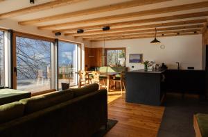 a kitchen and living room with a couch and a table at Chalet Astra, Whirlpool & Sauna in San Pancrazio dʼUltimo