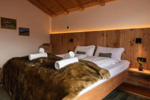 a bedroom with a large bed with a fur blanket at Chalet Astra, Whirlpool & Sauna in San Pancrazio dʼUltimo