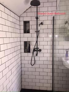 a shower in a bathroom with white tiled walls at Cardiff Mini Retreat in Cardiff