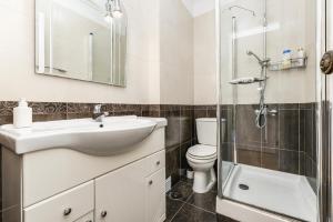 a bathroom with a sink and a toilet and a shower at Apartamento Mar Salgado Ericeira in Ericeira +18 photos