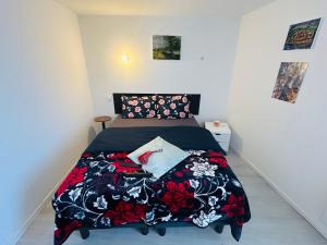 a bedroom with a bed with a black and red blanket at Maisonnette La Chouette in Azille