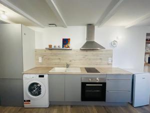 a kitchen with a sink and a washing machine at Maisonnette La Chouette in Azille