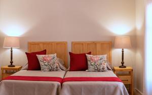 a bedroom with a bed with red pillows and two lamps at Scandi House in Louis Trichardt