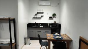 a small kitchen with a small table and a small table with chairs at Loft Moderno Goēde in Pomerode +9 photos