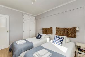 a bedroom with two beds and a couch at Apartamento Mar Salgado Ericeira in Ericeira
