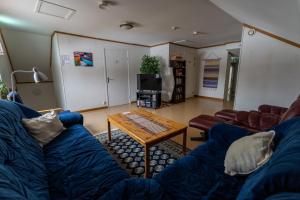 a living room with a blue couch and a coffee table at Öje Vandrarhem & Turistgård in Östra Öje