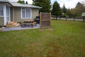 einen Hinterhof mit einem Picknicktisch und einem Grill in der Unterkunft Accommodation Fiordland -The Three Bedroom House at 226A Milford Road in Te Anau