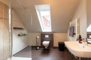 a bathroom with a toilet and a sink and a window at Pier17 Appartement 3 in Borkum