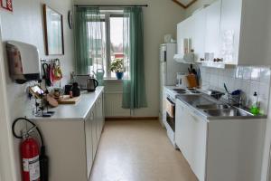 a kitchen with white cabinets and a sink at Öje Vandrarhem & Turistgård in Östra Öje +25 photos