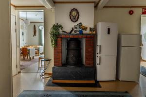 a living room with a fireplace and a refrigerator at Öje Vandrarhem & Turistgård in Östra Öje