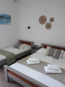 a room with two beds and a clock on the wall at Ntaskas apartments in Poulithra