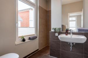 a bathroom with a sink and a window at Pier17 Appartement 5 in Borkum