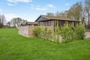 a house in the middle of a grass field at Athelington Lodge - Oak in Eye