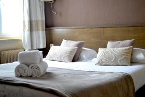 a bedroom with a bed with towels on it at Brit Hotel Le Surcouf in Saint Malo
