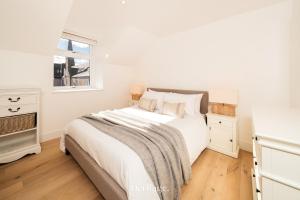a white bedroom with a bed and a window at The Old Sorting Office, Aboyne, Royal Deeside in Aberdeen