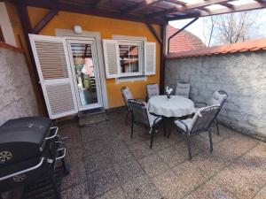 a patio with a table and chairs and a grill at Apartment by MICHELLE - Terme Čatež House in Čatež ob Savi