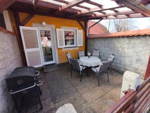 a patio with a table and chairs and a grill at Apartment by MICHELLE - Terme Čatež House in Čatež ob Savi