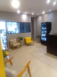 a living room with a yellow chair and chairs at Unity Hotel - Allianz SP in São Paulo