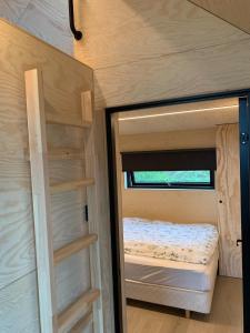 a small bedroom in a tiny house with a bed at Cabin in the orchard in Sandane