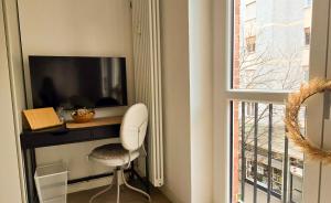 a room with a desk with a television and a chair at Suite and Home between Milano, Malpensa e Como Lake in Saronno