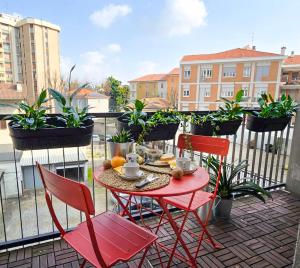a red table and chairs on a balcony with plants at Suite and Home between Milano, Malpensa e Como Lake in Saronno